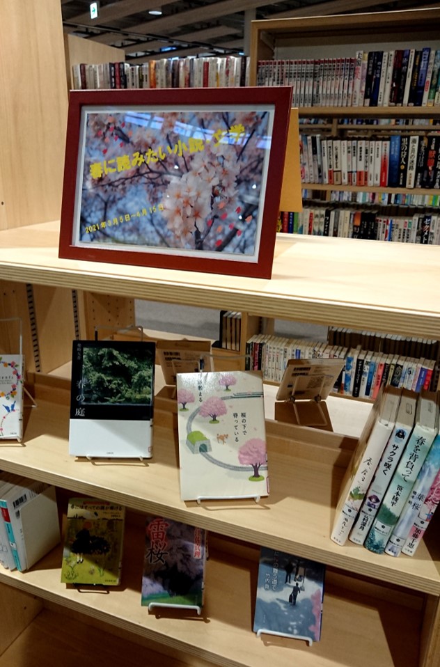 春に読みたい本の展示写真。桜の写真の下に関連する本が並んでいる。