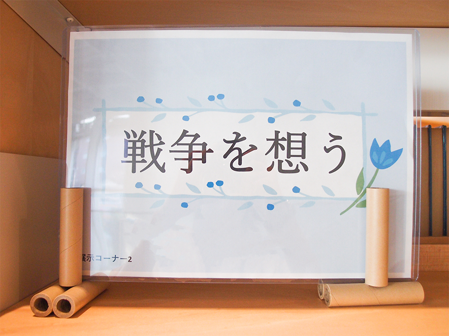 「戦争を想う」の展示写真１　タイトルに青い花のイラストが添えられている