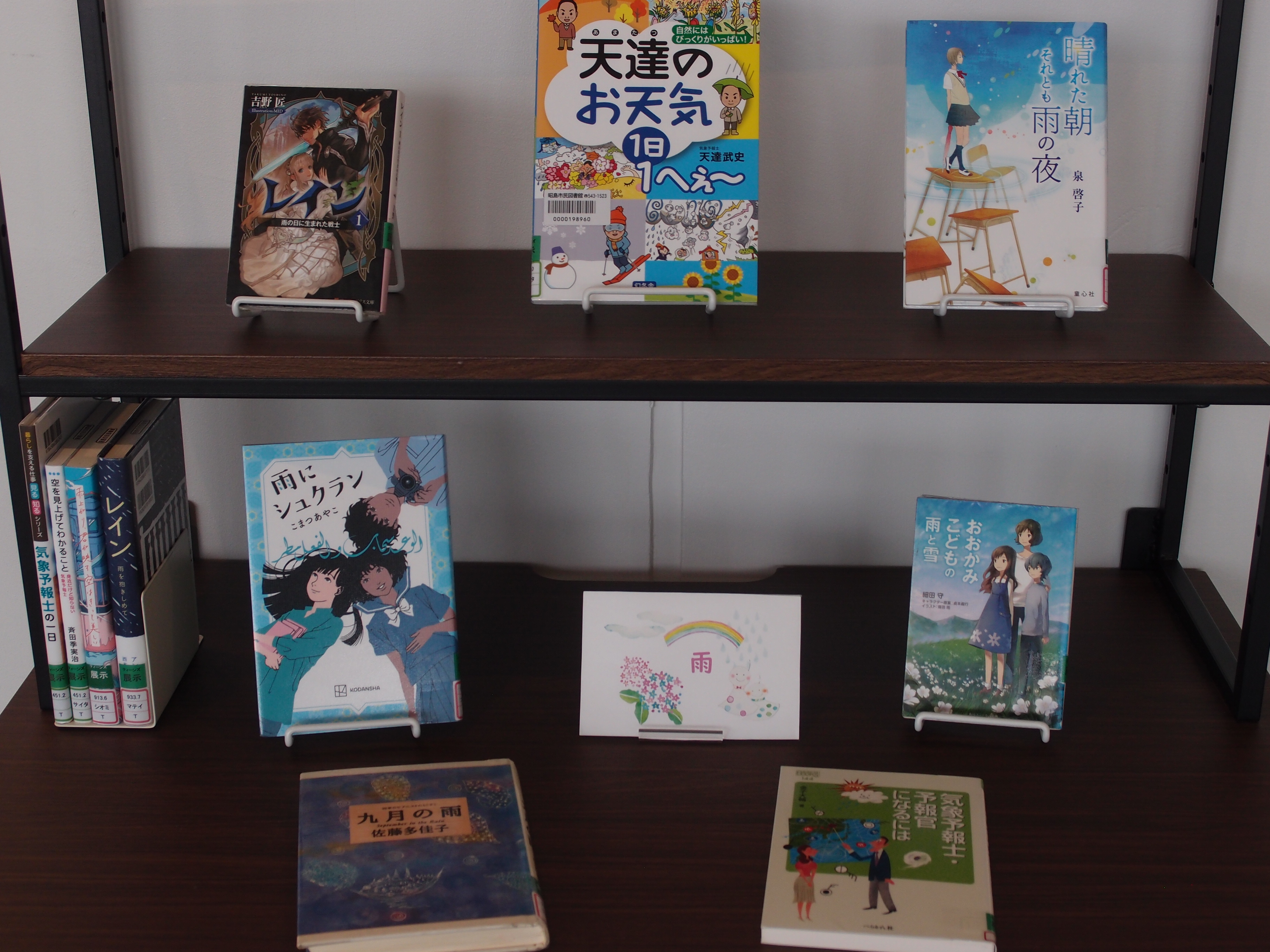 6月ティーンズ展示の写真。雨や天気にちなんだ本を展示。