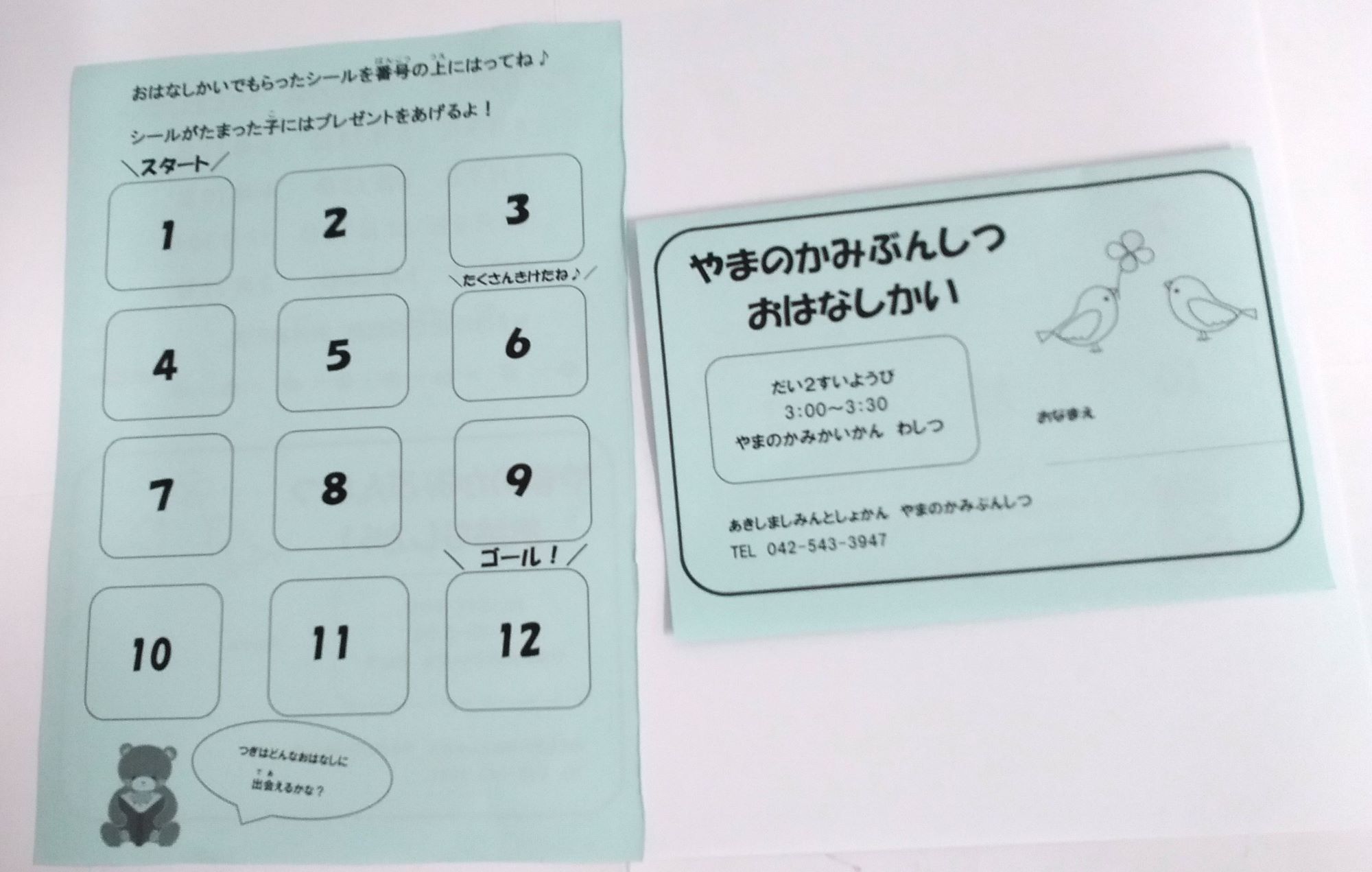 2枚の紙が写った写真。おはなし会の案内が書かれている