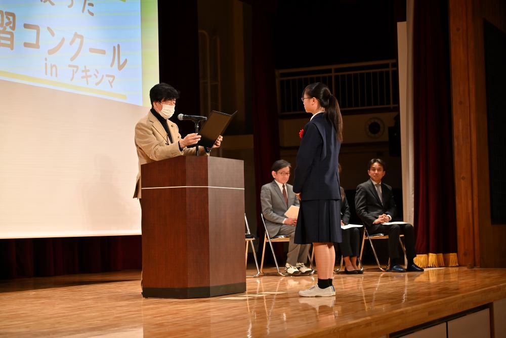 舞台上で賞状を渡される様子の写真