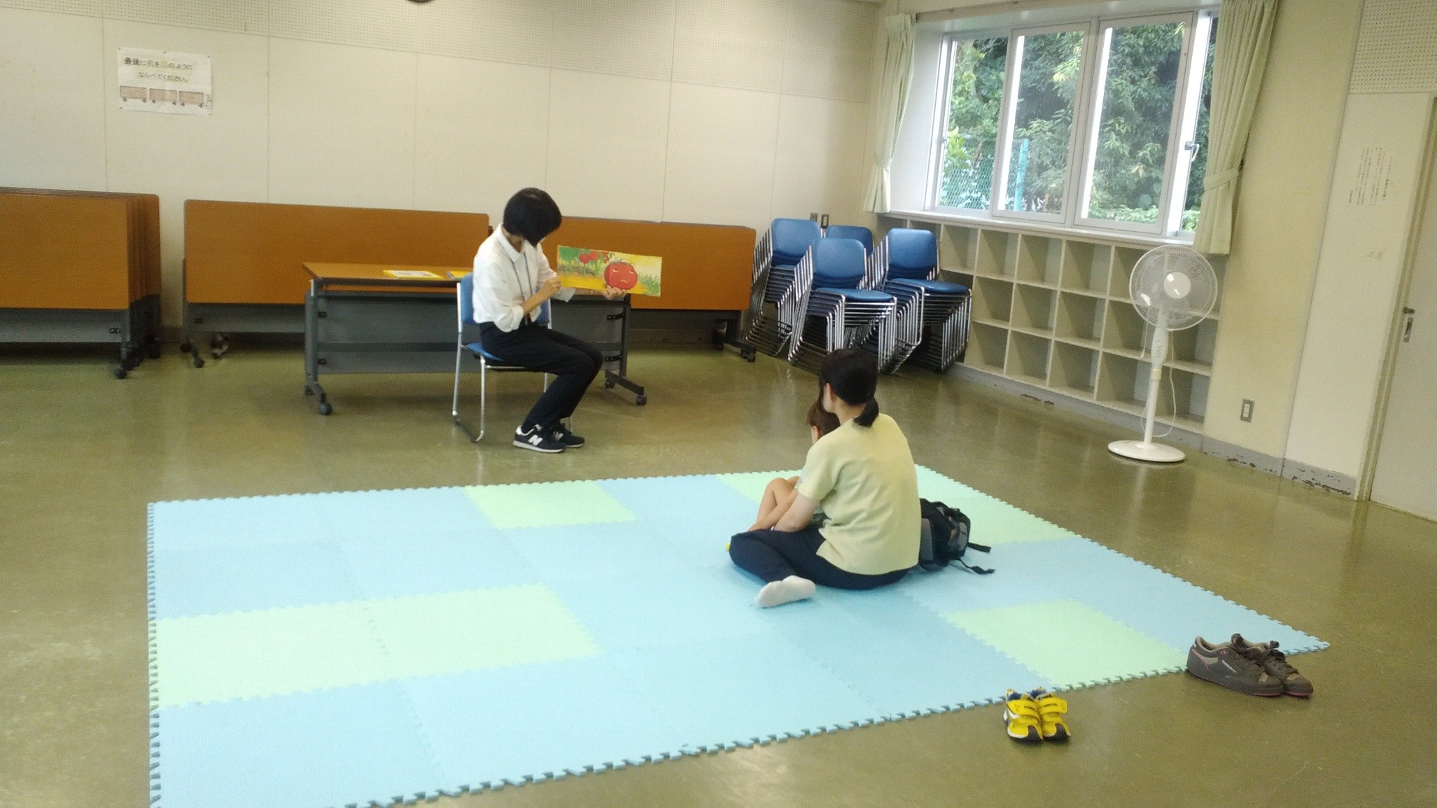 女性がお子さんに向けて絵本を読み聞かせしている様子の写真