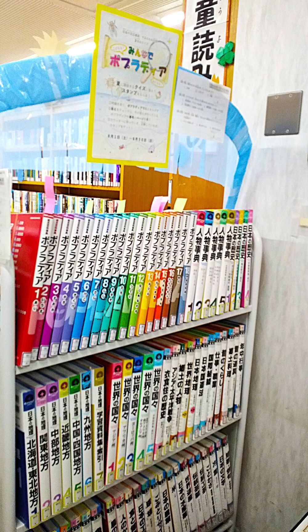棚に本が並んでいて、イベント紹介のポスターが貼られている様子の写真